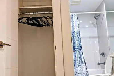a bathroom with a shower with a curtain and a window at 2 Bed Apartment Free Parking Central Location in Vancouver
