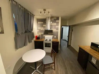 a small kitchen with a table and a stove at Dt 1Bed 1bath Cozy Suite 8 Min Walk To Arena in Edmonton