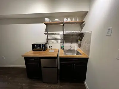 a small kitchen with a sink and a microwave at Dt 1Bed 1bath Cozy Suite 8 Min Walk To Arena in Edmonton