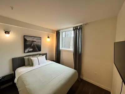 a bedroom with a large bed and a window at Dt 1Bed 1bath Cozy Suite 8 Min Walk To Arena in Edmonton