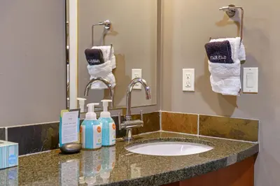 a bathroom with a sink and a mirror and towels at Adventurer's Escape~ Mountain Luxury Resort in Canmore