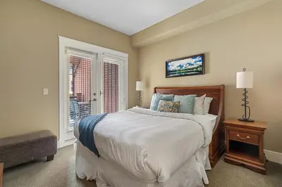 a bedroom with a large bed and a window at Adventurer's Escape~ Mountain Luxury Resort in Canmore