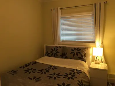 a small bedroom with a bed and a window at Arbutus summer house in Vancouver