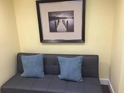 a couch with two pillows and a picture on the wall at Arbutus summer house in Vancouver