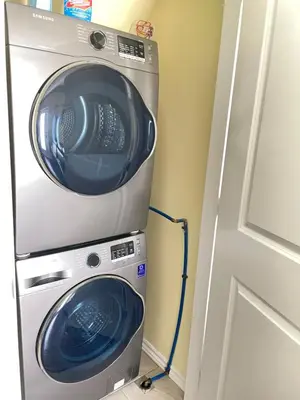 a washer and dryer in a room next to a door at Arbutus violet room in Vancouver