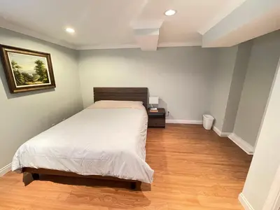 a bedroom with a bed and a wooden floor at Arbutus violet room in Vancouver