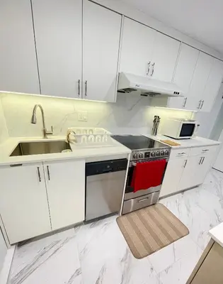 a kitchen with white cabinets and a sink and a stove at Arbutus Jasmine room in Vancouver