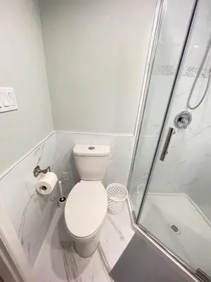 a white bathroom with a toilet and a shower at Arbutus Jasmine room in Vancouver