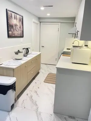 a kitchen with white marble floors and a sink at Arbutus Jasmine room in Vancouver