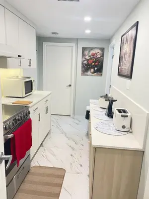a kitchen with white cabinets and a white counter top at Arbutus Jasmine room in Vancouver