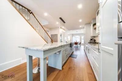 a kitchen with white cabinets and a blue island at The Azure, Near DT & University, TWO King Beds! in Edmonton