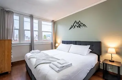 a bedroom with a large bed with towels on it at Downtown Home Private Hot Tub Walkable Location in Revelstoke