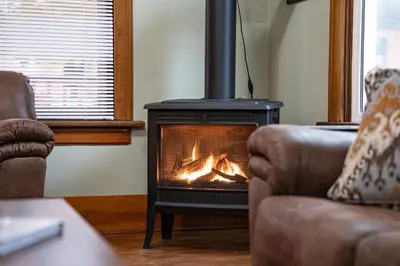 a fireplace in a living room with a fire in it at Downtown Home Private Hot Tub Walkable Location in Revelstoke
