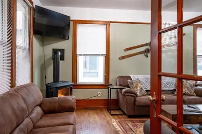 a living room with a couch and a wood stove at Downtown Home Private Hot Tub Walkable Location in Revelstoke
