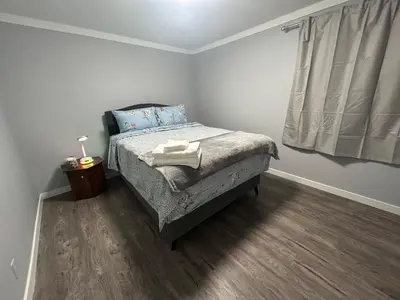 a small bedroom with a bed and a window at Cute Highlandpark (Lower A Unit) in Calgary