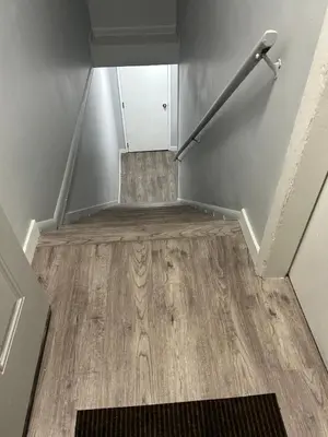 an empty stairwell with a metal railing and wooden floor at Cute Highlandpark (Lower A Unit) in Calgary
