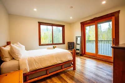 a bedroom with a bed and a balcony at River Safari Lodge in Blue River