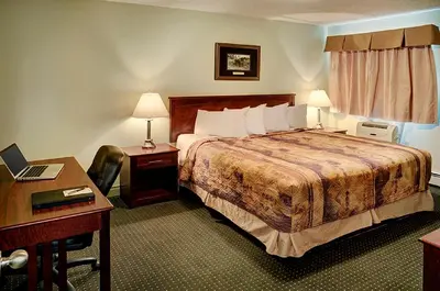 a hotel room with a bed and a desk at Nova Inn Edson in Edson