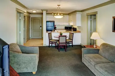 a living room with a table and chairs and a kitchen at Nova Inn Edson in Edson