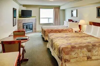 a hotel room with two beds and a fireplace at Nova Inn Edson in Edson