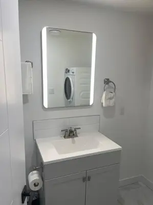 a white bathroom with a sink and a mirror at Modern 2Bedroom suite in SW Edmonton close to Edmonton International Airport in Edmonton