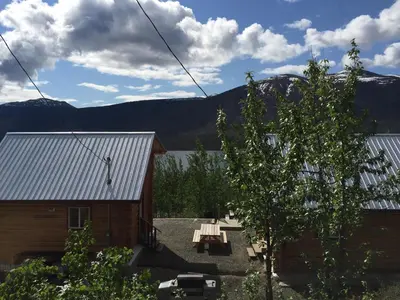 a house with a picnic table and a tree at Cabins Over Crag Lake in Carcross