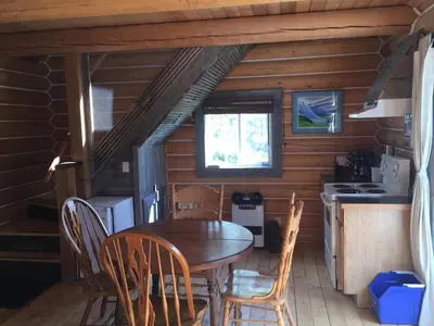a dining room with a table and chairs in a cabin at Cabins Over Crag Lake in Carcross