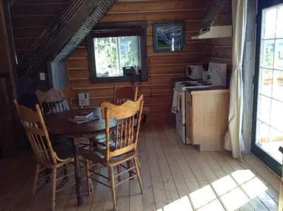 a kitchen with a table and chairs in a cabin at Cabins Over Crag Lake in Carcross
