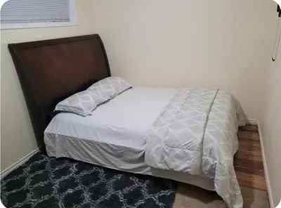 a bed with a wooden headboard in a bedroom at Basement Room in Calgary