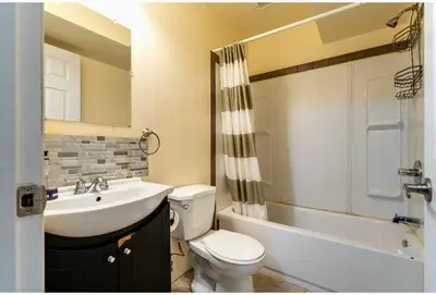 a bathroom with a sink and a toilet and a bath tub at Basement Room in Calgary