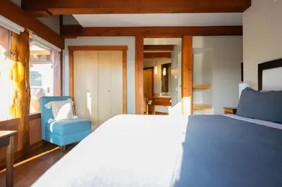 a bedroom with a bed and a blue chair at Waterfront Condo in Ucluelet in Ucluelet