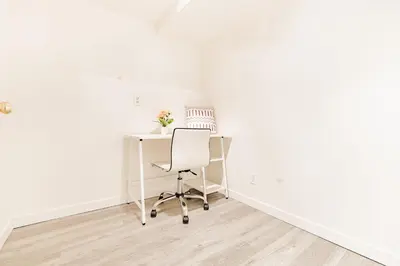 an office with a white desk and a chair at Walkout Basement Suite, 2 BDR 4BD, Bright and Spacious in Calgary