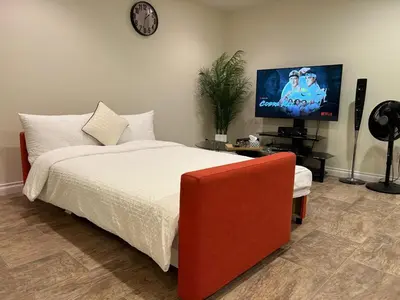 a bedroom with a bed and a flat screen tv at A private suite in Port Moody in Port Moody