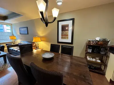 a dining room with a table and a couch at Solara Escape - 2BR Retreat with Pool - Hot Tub - Gym - Spa in Canmore
