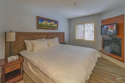 a bedroom with a large bed and a fireplace at Solara Suite with Indoor Pool / Hot tub / Parking in Canmore