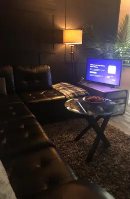 a living room with a couch and a table with a laptop at Cozy Haven! in Edmonton