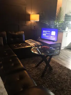 a living room with a couch and a table with a laptop at Cozy Haven! in Edmonton