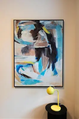 a painting hanging on a wall with a lamp at Tally Ho by Revelstoke Vacations in Revelstoke