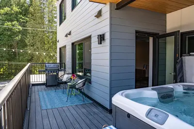 a hot tub on the deck of a house at Tally Ho by Revelstoke Vacations in Revelstoke