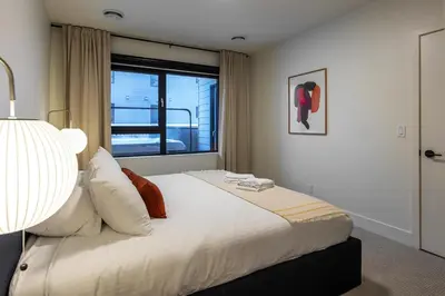 a bedroom with a large bed with a window at Tally Ho by Revelstoke Vacations in Revelstoke