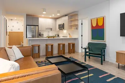 a living room with a couch and a kitchen at Tally Ho by Revelstoke Vacations in Revelstoke