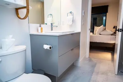 a bathroom with a sink and a toilet and a bed at Separate Reality Retreat by Revelstoke Vacations in Revelstoke