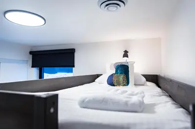 a bedroom with a large white bed with a blue pillow at Separate Reality Retreat by Revelstoke Vacations in Revelstoke