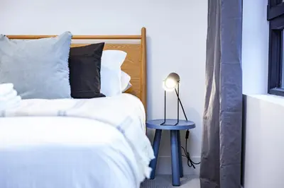 a bedroom with two beds and a blue table with a lamp at Tumbledown Condo by Revelstoke Vacations in Revelstoke