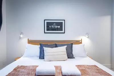 a bedroom with a white bed with blue pillows at Tumbledown Condo by Revelstoke Vacations in Revelstoke