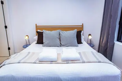 a bed with two pillows on it with two lamps at Tumbledown Condo by Revelstoke Vacations in Revelstoke