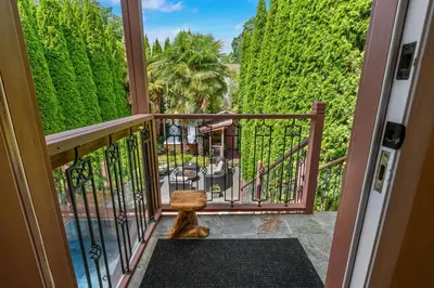 a cat sitting on a balcony looking out the door at Luxury Retreat in Vancouver in Vancouver