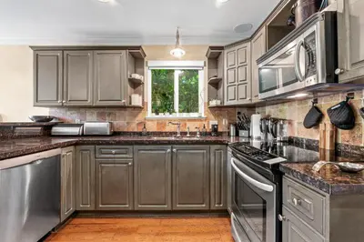 a kitchen with gray cabinets and stainless steel appliances at Luxury Retreat in Vancouver in Vancouver