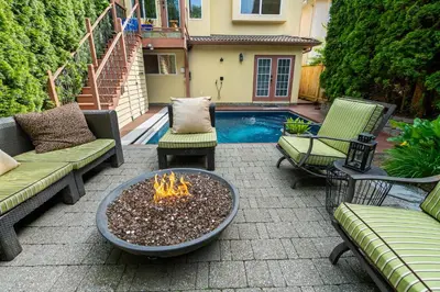 a patio with a fire pit and chairs and a pool at Luxury Retreat in Vancouver in Vancouver