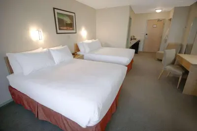 a hotel room with two beds and a desk at Eldorado, a Coast Hotel in Dawson City